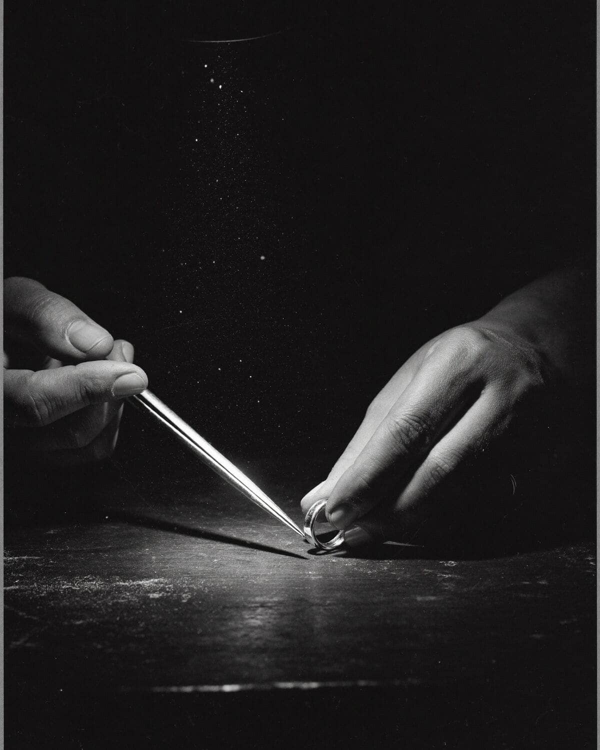 Hands of the maker over a stone on black velvet